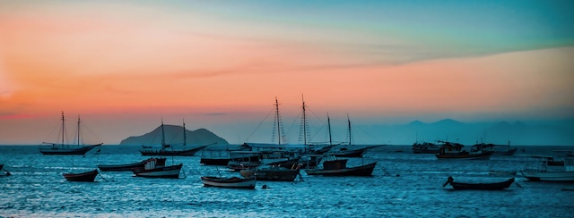 Boats on still water at sunset - A rising tide lifts all boats